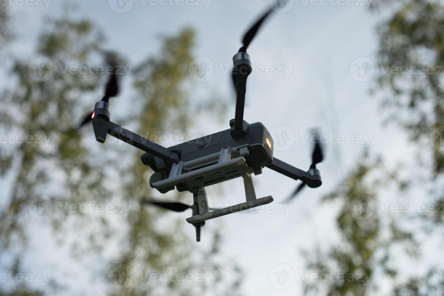 Drone takes off in forest. Quadro copter flying. shooting in nature. photo