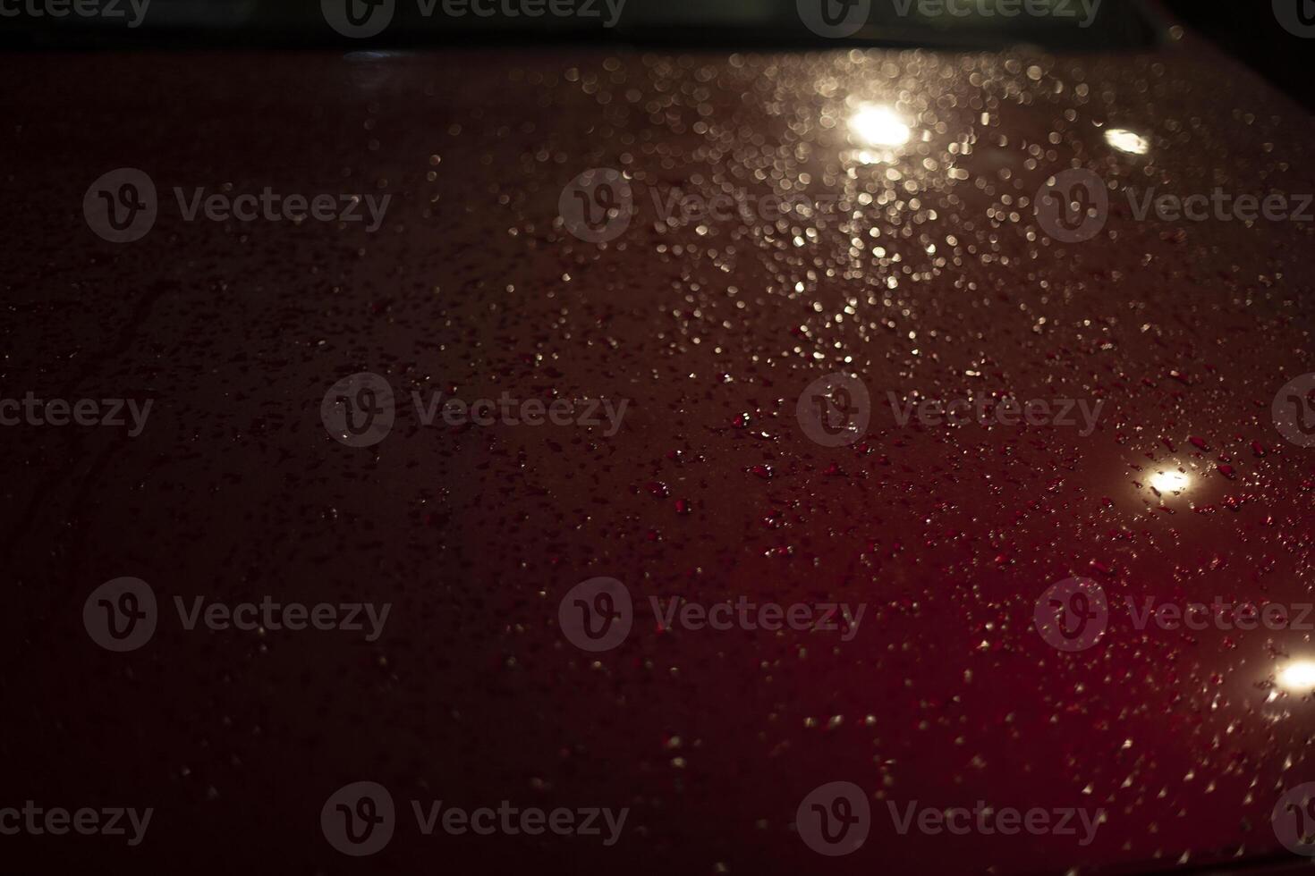 Wet car in parking lot. Drops on hood of car. Parking in detail at night. photo
