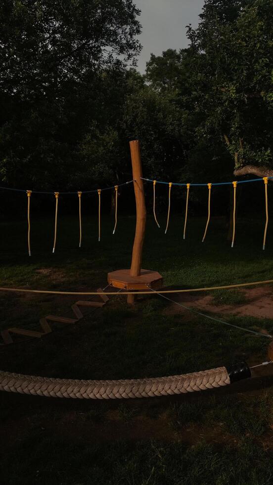 Wooden obstacle on the playground standing on green grass under cloudy sky photo