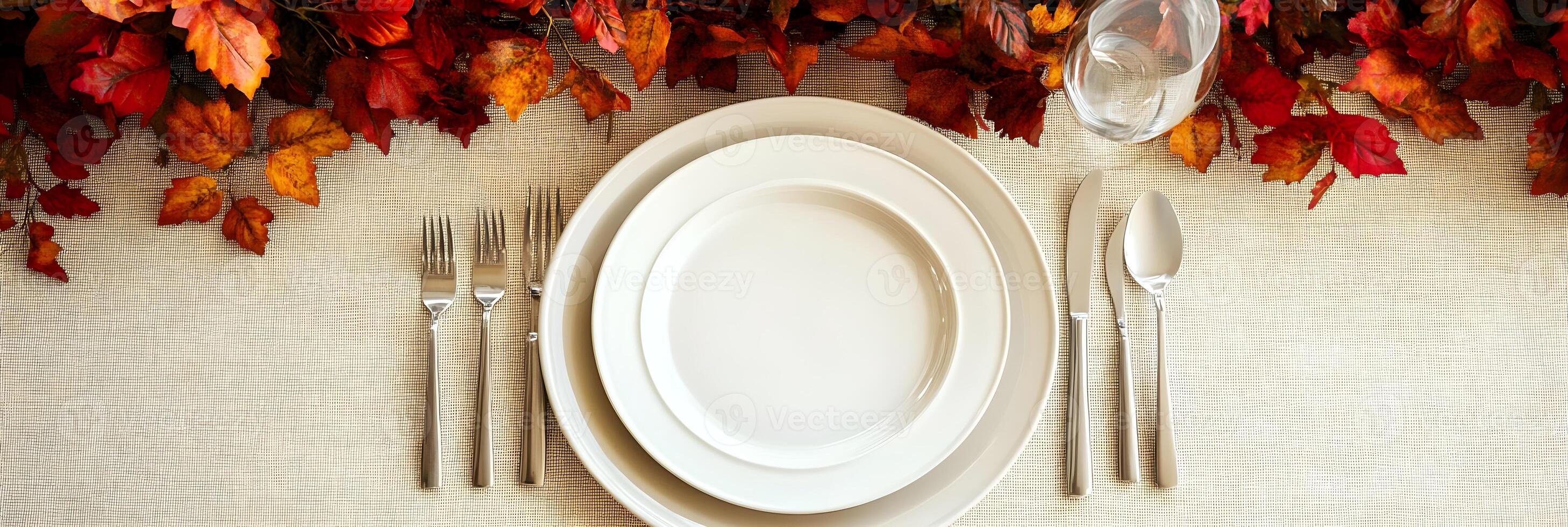 Autumn Table Setting with White Plates and Fall Leaves photo