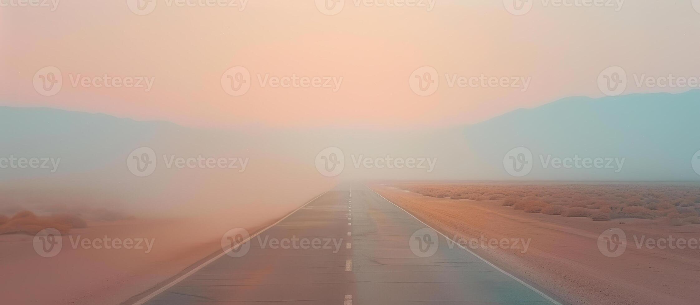 An empty road in the desert with a foggy sky photo