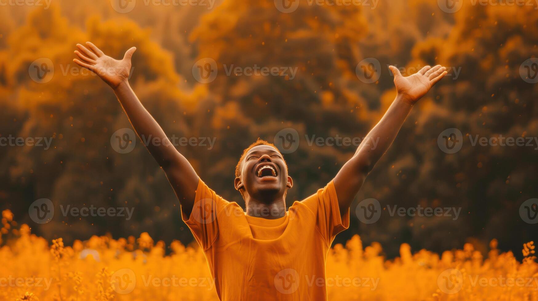 A man with his hands up in the air in a field photo