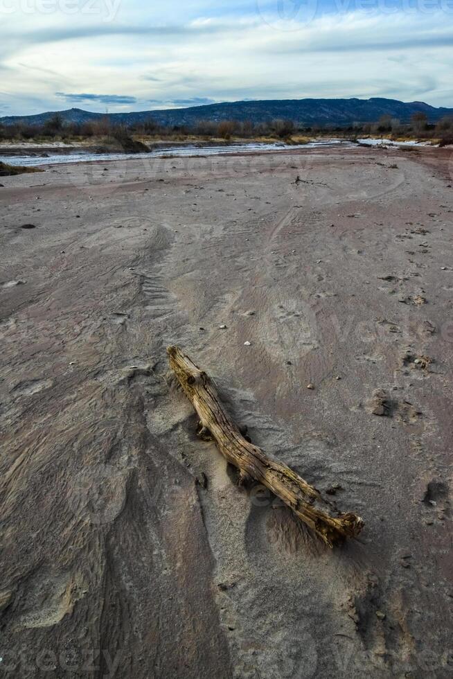 Cracked red clay and white salt on the surface in a dried riverbed in the desert of New Mexico, USA photo
