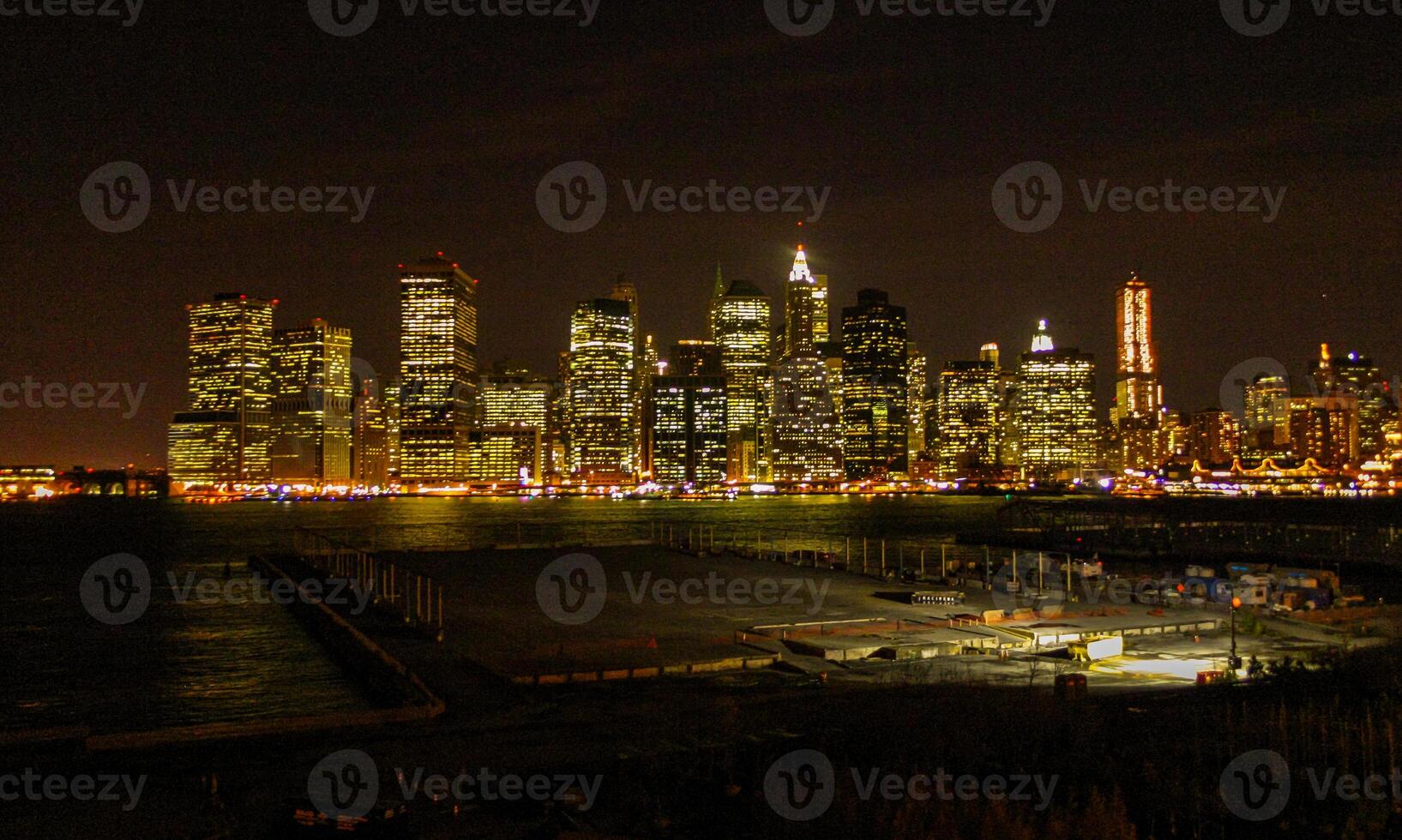 View of the night Manhattan, the lights of skyscrapers glowing at night against the black sky, USA photo