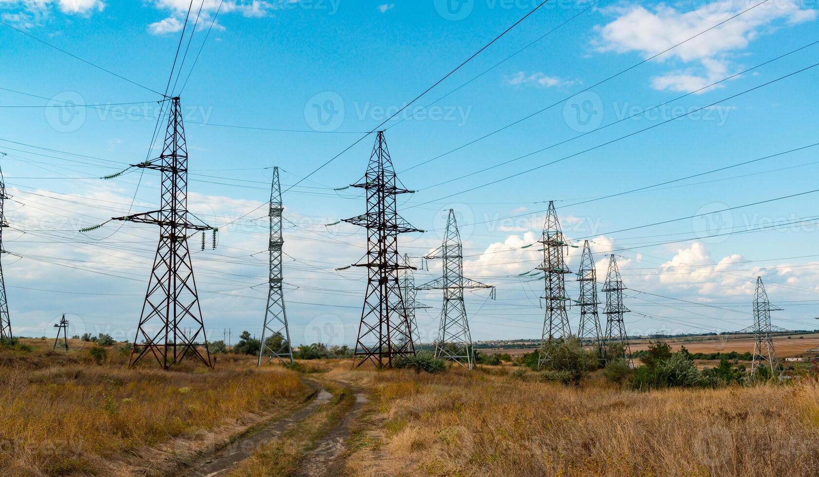 High-voltage lines on steel structures with wires against the background of the sky with clouds photo