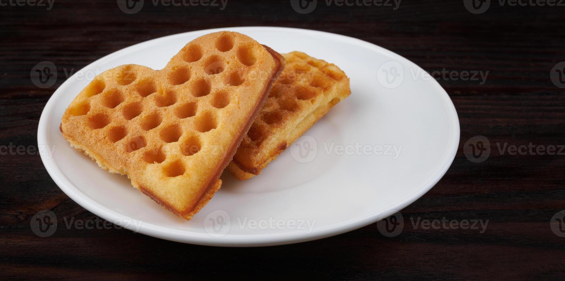 Two Viennese waffles lie on a white plate. Viennese waffles in the shape of a heart. photo