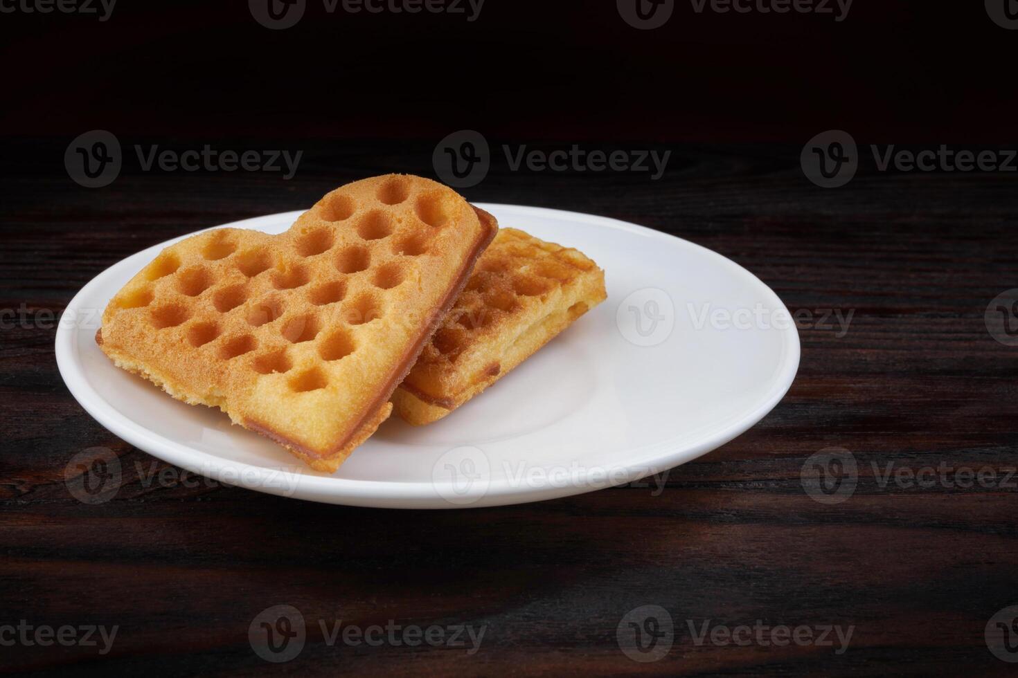 Two Viennese waffles lie on a white plate. Viennese waffles in the shape of a heart. photo