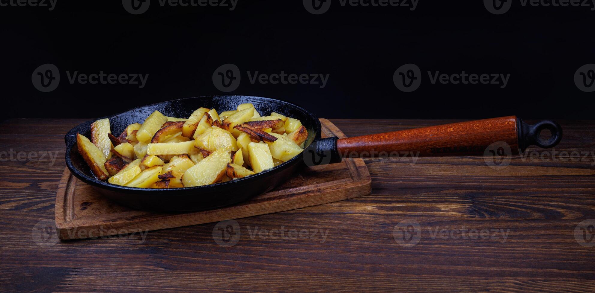 Roasted potatoes. Potatoes fried in butter in a cast iron frying pan. photo
