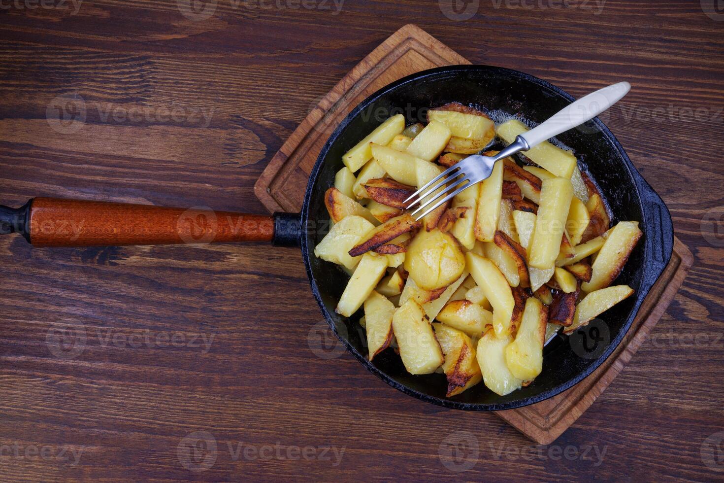 Roasted potatoes. Potatoes fried in butter in a cast iron frying pan. photo
