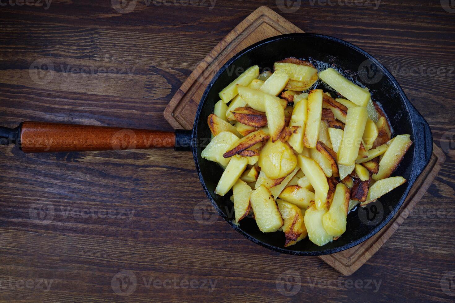 Roasted potatoes. Potatoes fried in butter in a cast iron frying pan. photo