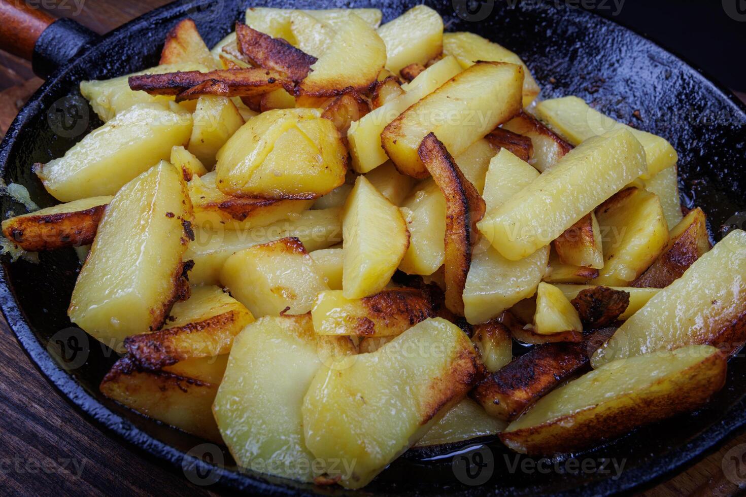 Roasted potatoes. Potatoes fried in butter in a cast iron frying pan. photo