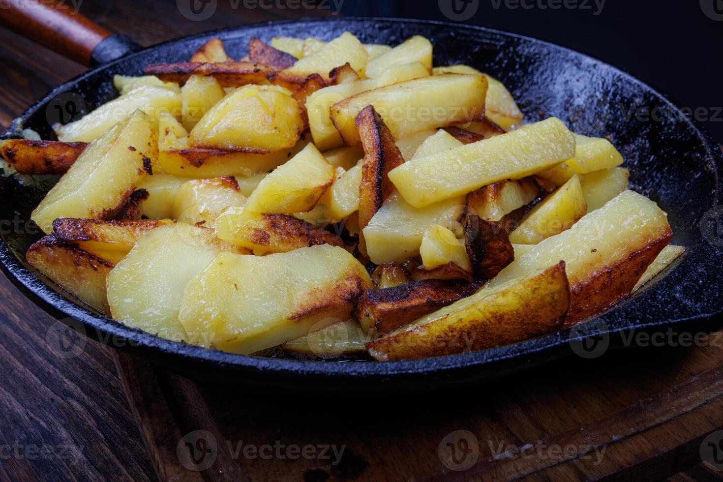 Roasted potatoes. Potatoes fried in butter in a cast iron frying pan. photo