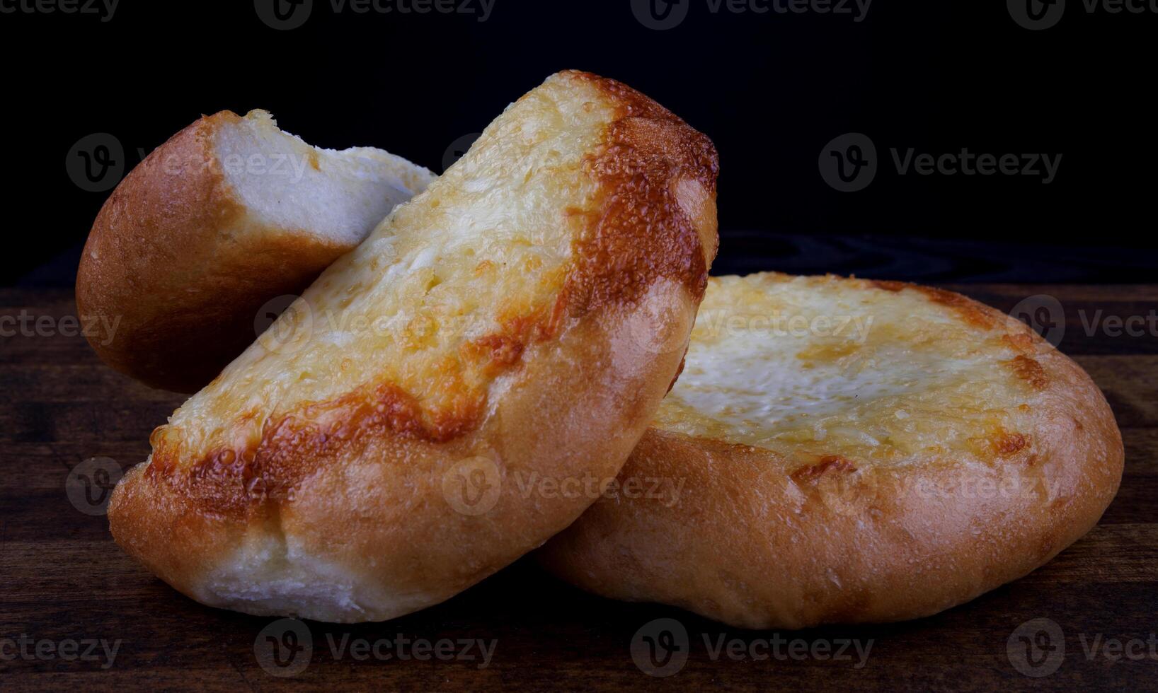 Khachapuri. Bun with cheese on a wooden background. Cheese pie. photo