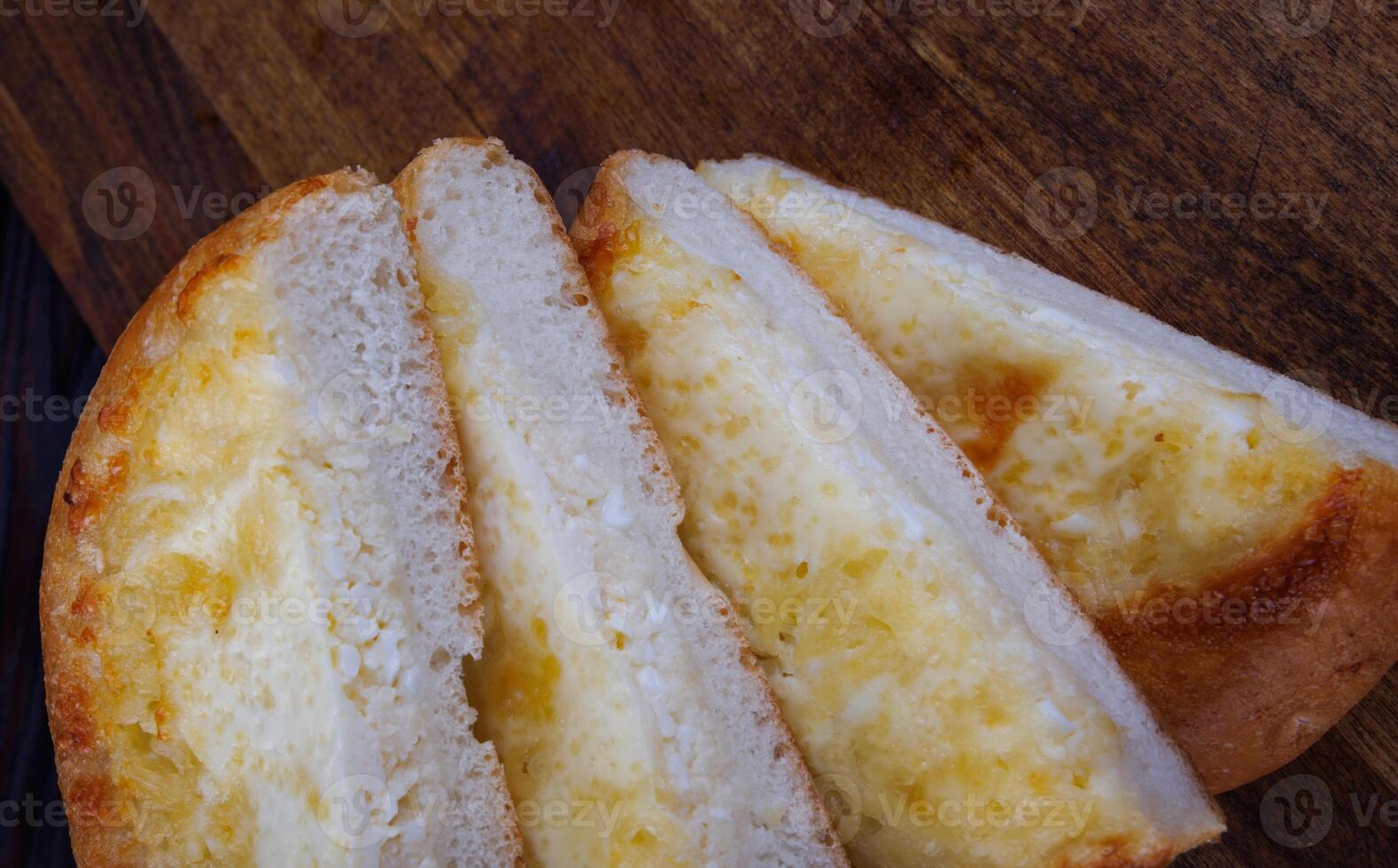 Khachapuri. Bun with cheese on a wooden background. Cheese pie. photo