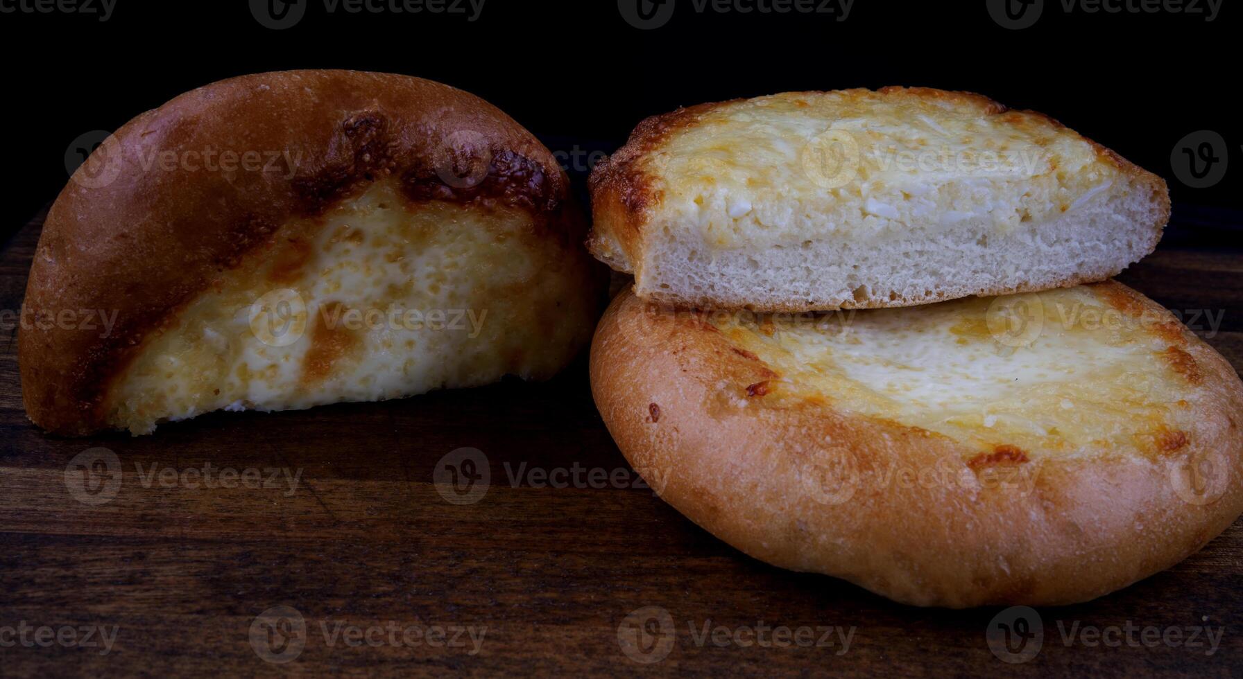 Khachapuri. Bun with cheese on a wooden background. Cheese pie. photo
