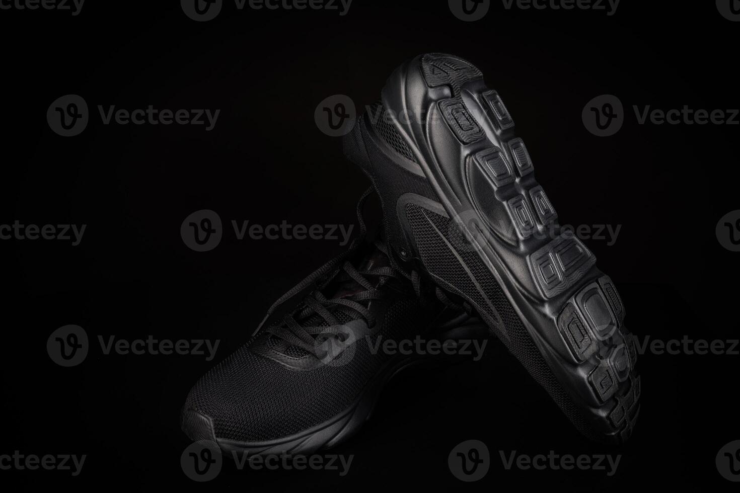 A pair of black sneakers on a black background. Beautiful black sneakers. photo