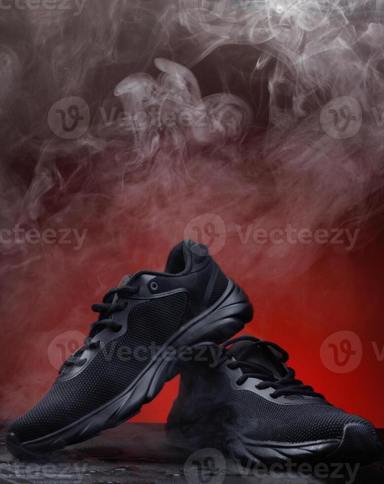 Beautiful black sneakers on a red background. Smoke around black sneakers. Smoking sneakers. photo