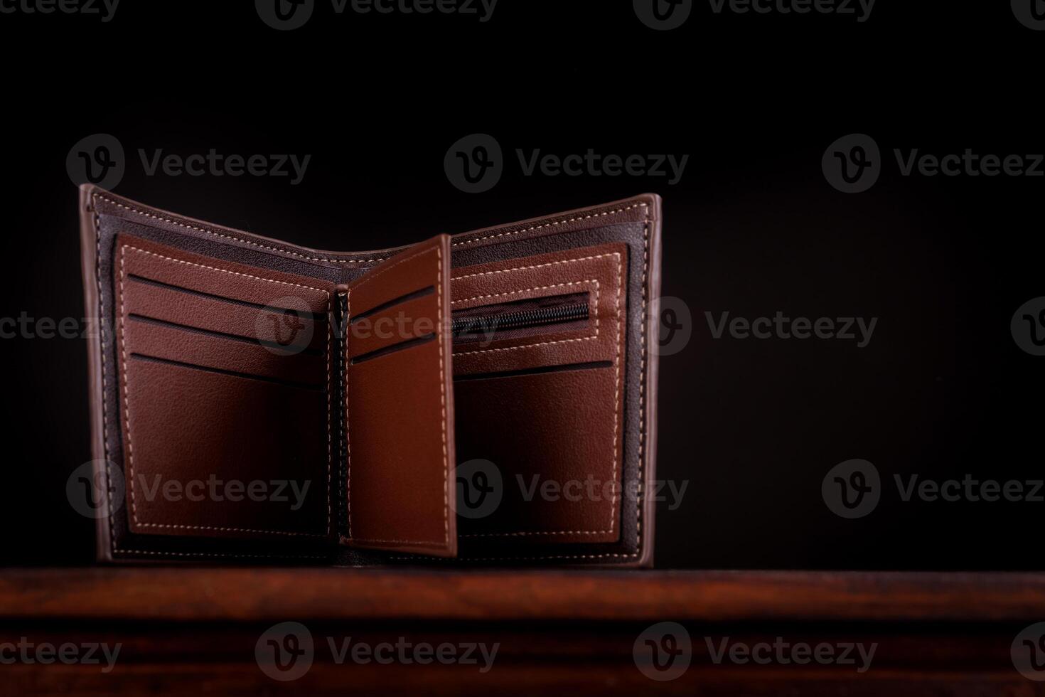 An open leather wallet on a dark background. photo