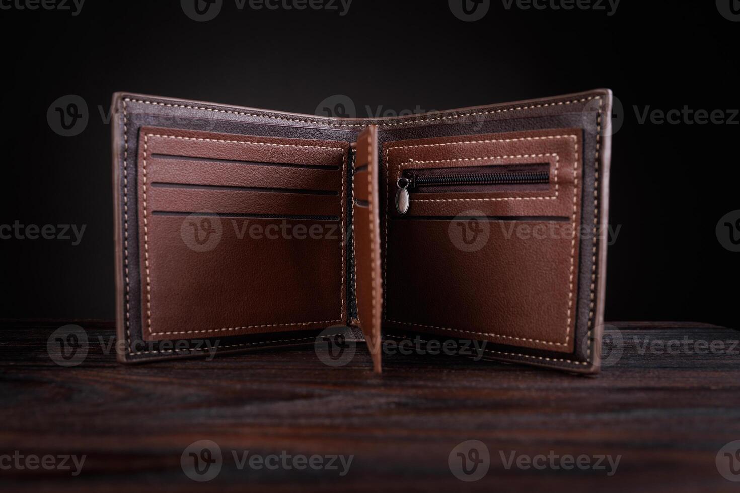 An open leather wallet on a dark background. photo