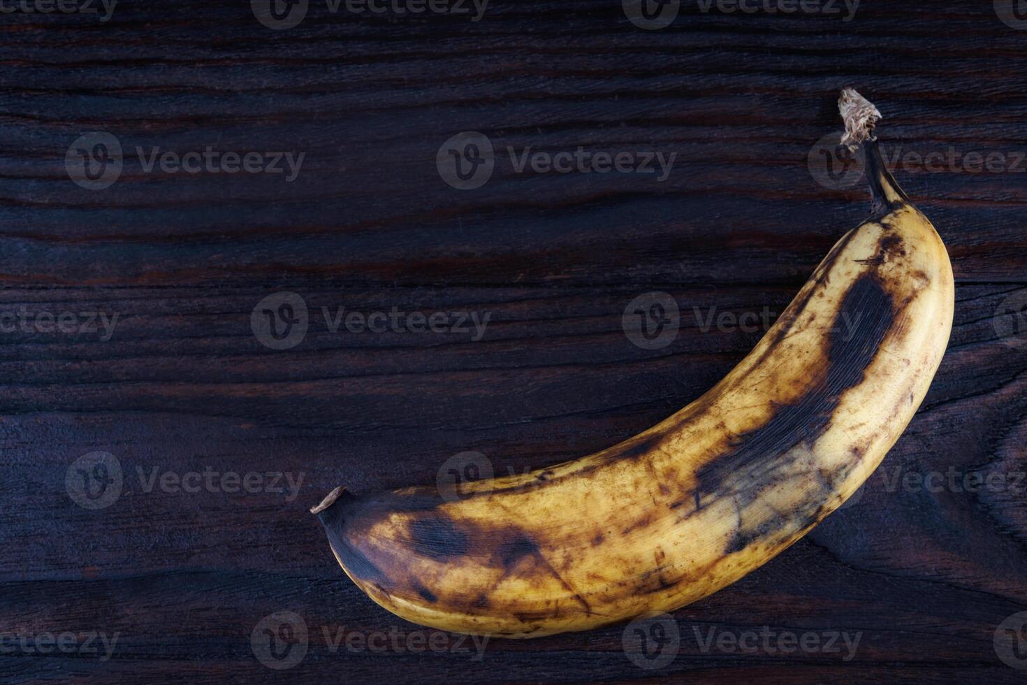 Overripe banana on a wooden surface. photo