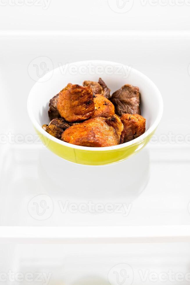 yesterday's fried meat in bowl close up on shelf photo