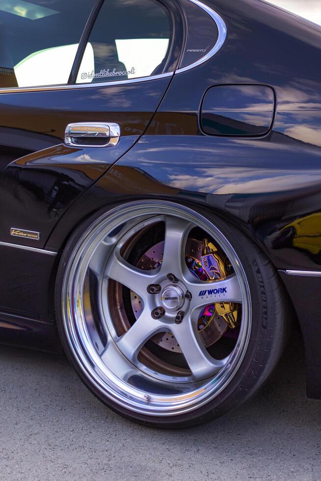 15.09.2024. Novosibirsk, Midday, Lowered on Work Meister wheels. Stance and Camber, colorful brake caliper vertical photo