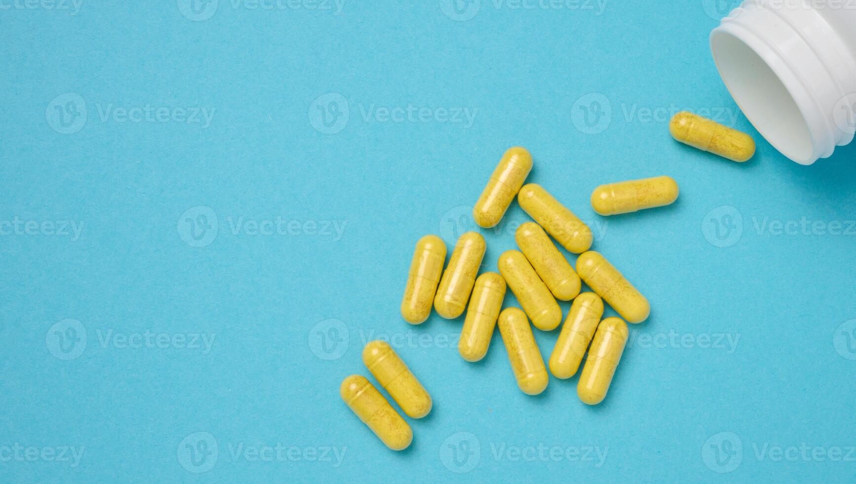 Yellow pills in a capsule on a blue background, pain treatment photo