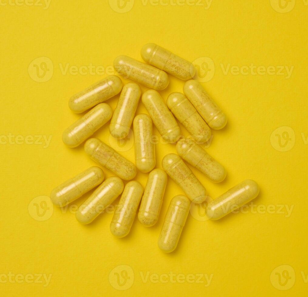 Yellow pills in a capsule on a yellow background, pain treatment photo