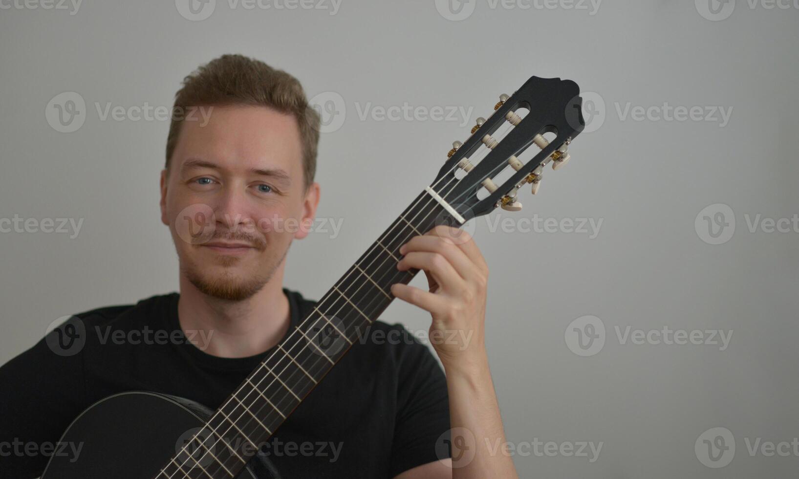 A man playing the guitar. Hands on the strings. Close-up portrait. Chord selection. Musician playing electric guitar. Banner wallpaper with copy space at the white background photo