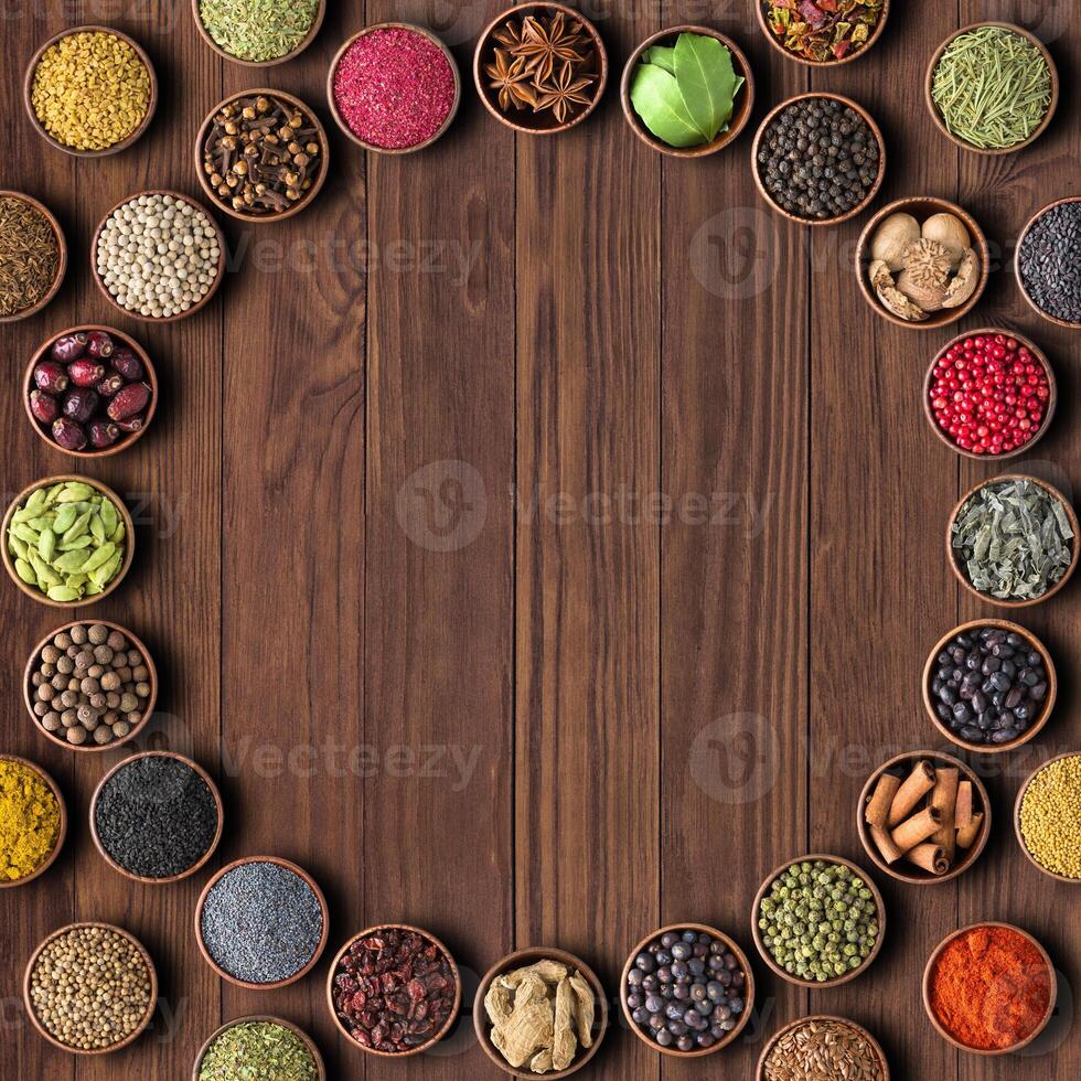 Herbs and spices over wooden table background. multicolored seasoning,top view with copy space photo