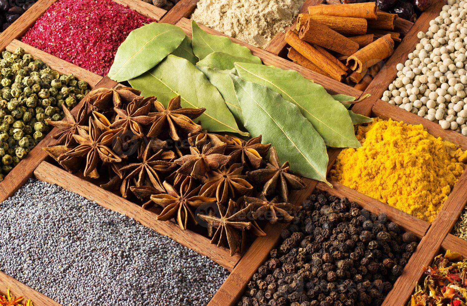 Various spices in wooden box, top view. Condiments for cooking food as background. photo