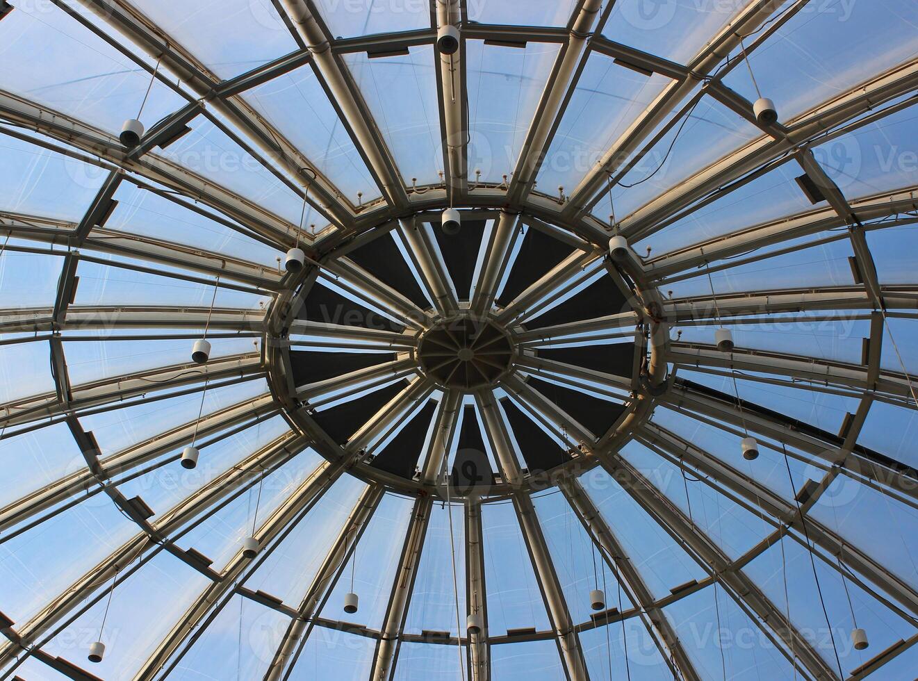 Metal structure of a round glass roof with ceiling spotlights photo