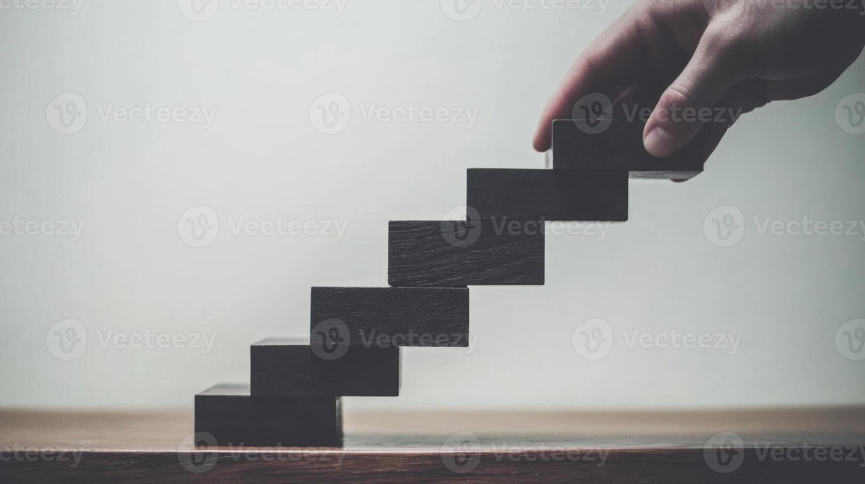 Businessman building a career path with wooden blocks photo