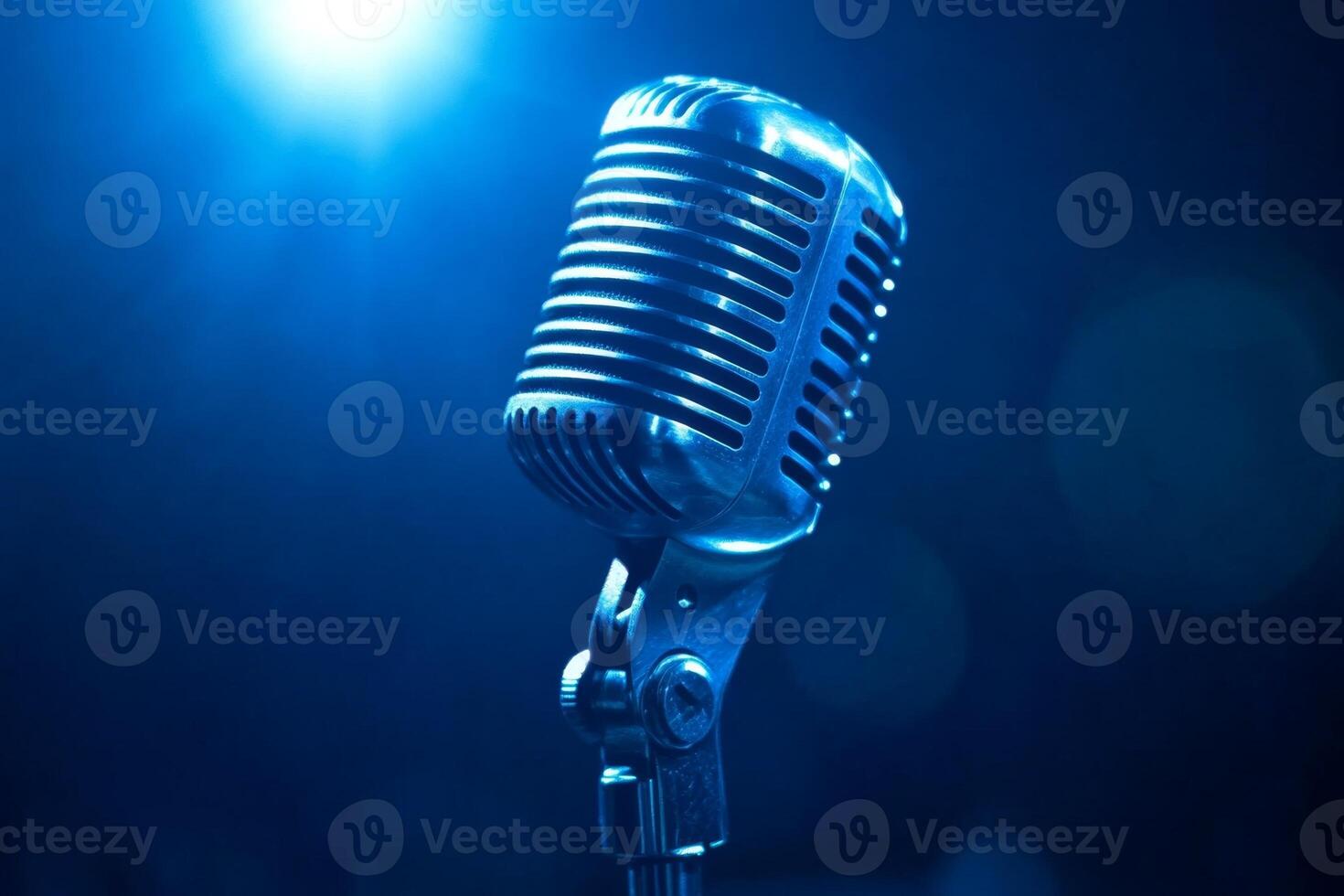 Vintage microphone standing in blue light on stage photo