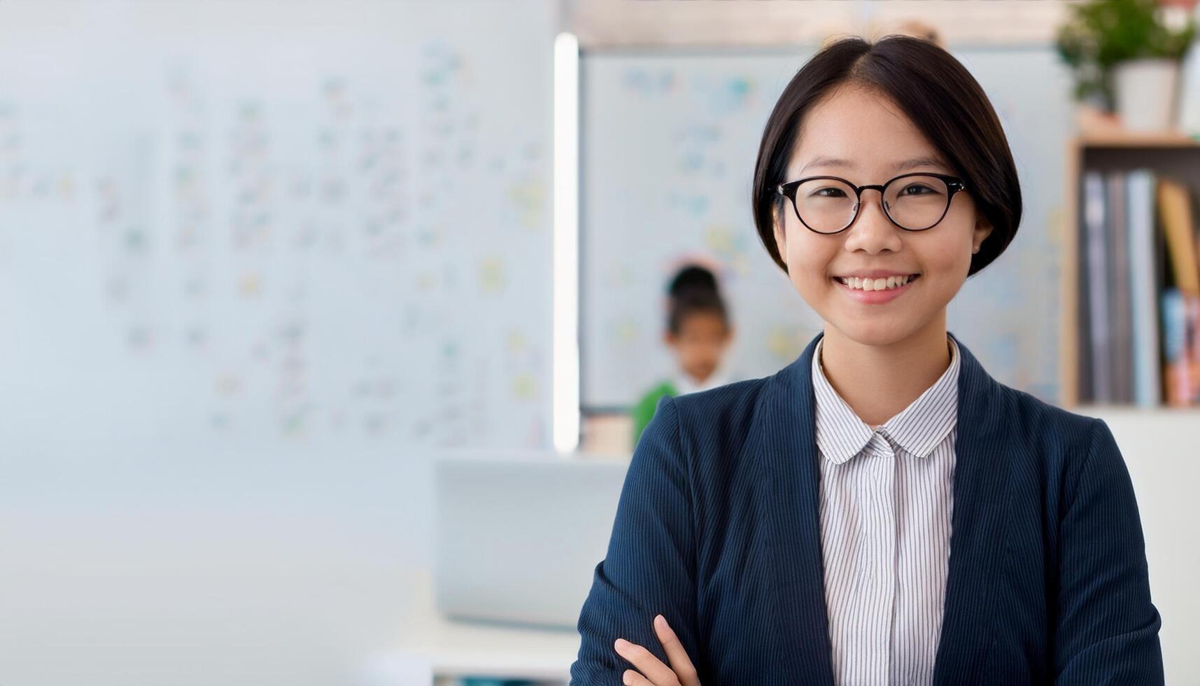 Japanese preschool teacher smiling warmly in a classroom filled with children. The teacher, The vibrant learning environment in the background makes this image perfect for educational themes, school photo