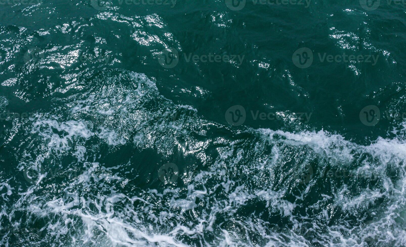 Beautiful sea waves with foam of blue and turquoise color. Abstract blue sea water with white wave. Blue and white waves of the ship road on the water sea ocean. photo