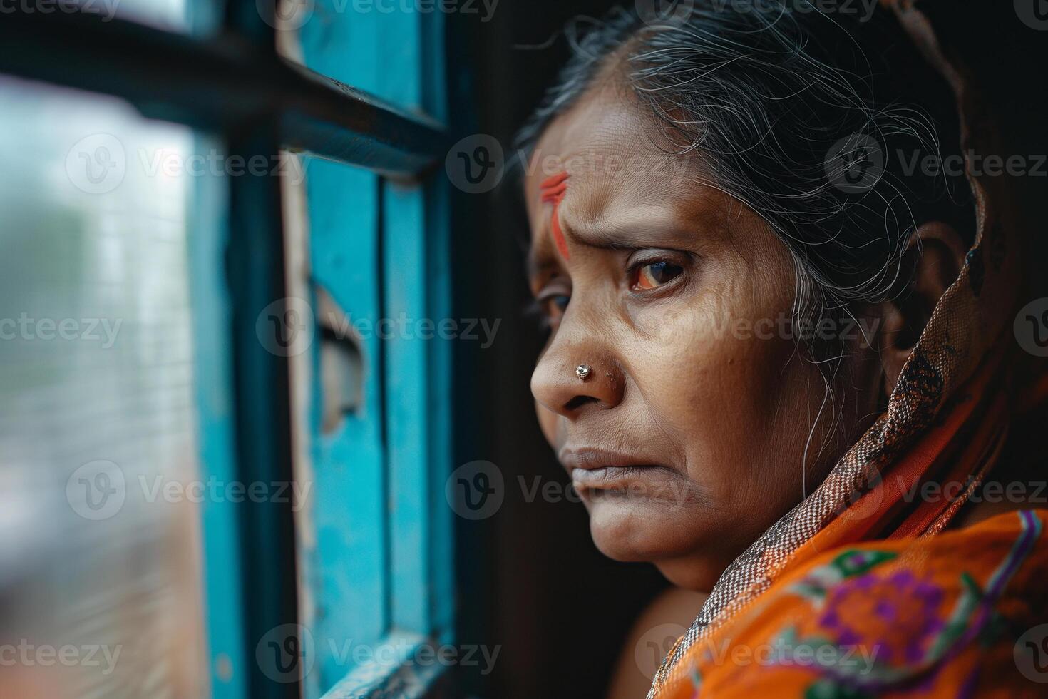 Portrait of sad beautiful woman crying and standing by the window photo