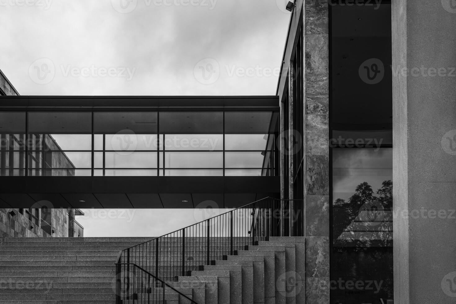 black and white photo of a building with a glass walkway and stairs