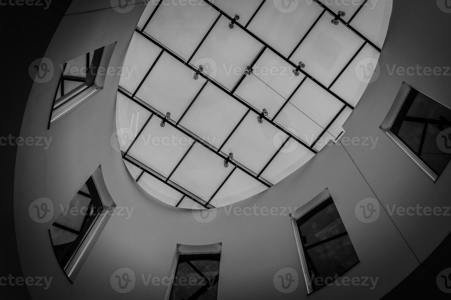image is a black and white photo of a building with a dome-shaped roof and a large window