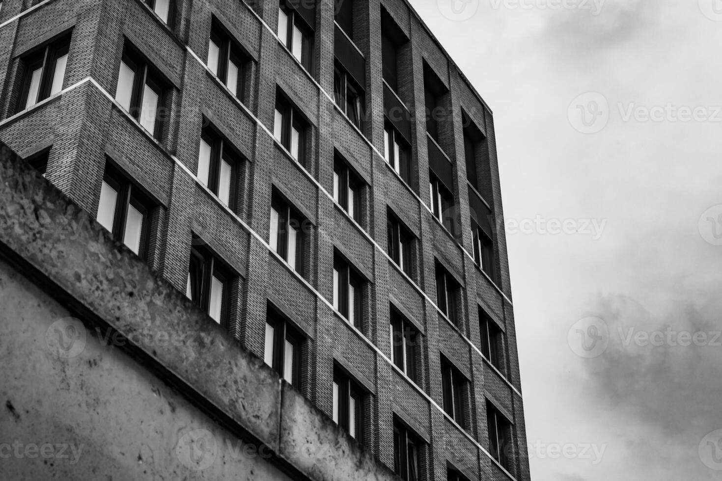brick building with many windows and a cloudy sky in the background photo