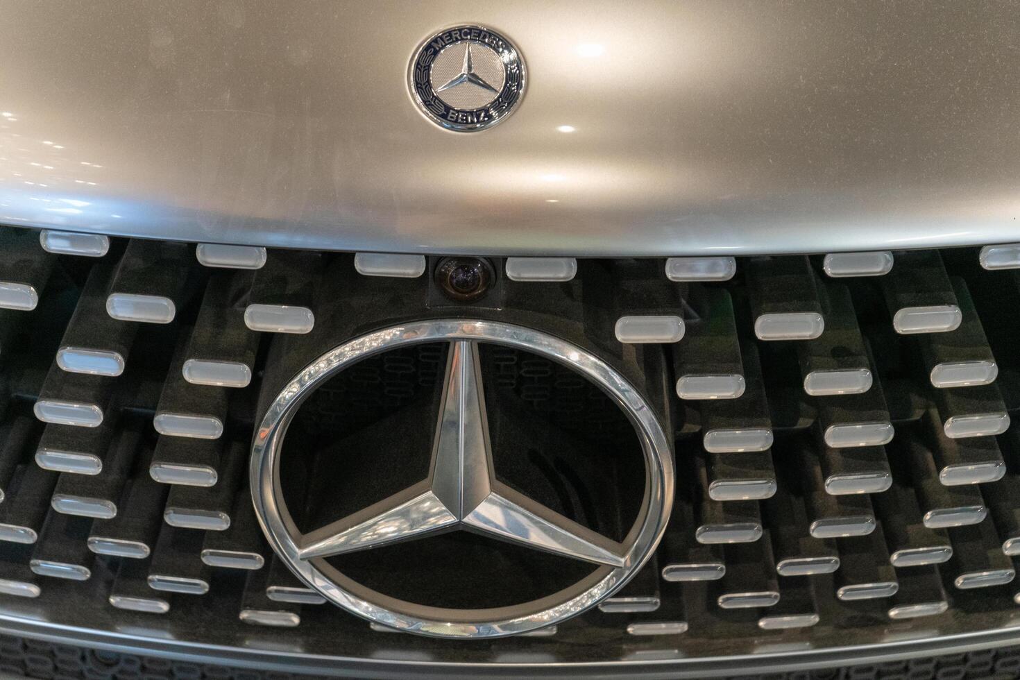 Silver Mercedes car. Bumper and headlights. Logo emblem on the hood. Warsaw, Poland - 28.07.2023. photo