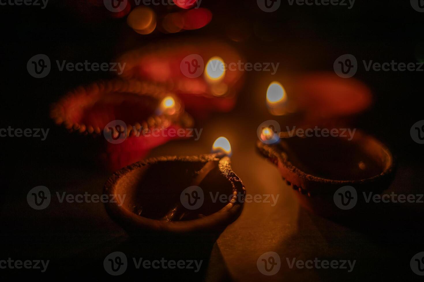 Glowing clay lamps during Indian festival Diwali celebrations on black background photo