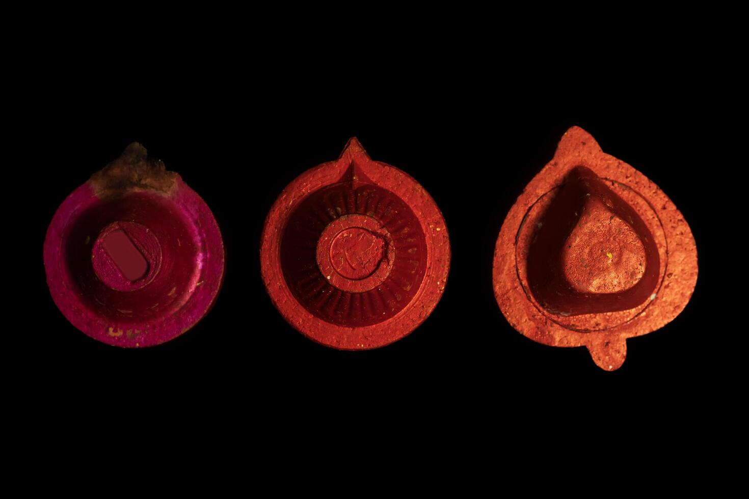 Close up of diwali clay diya oil lamps on black background. photo