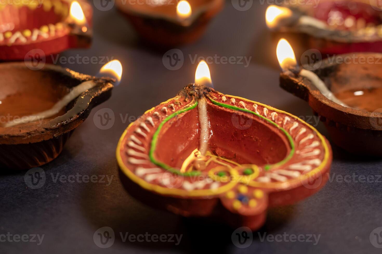 Beautiful diya lights lit during Diwali celebration on black background. photo