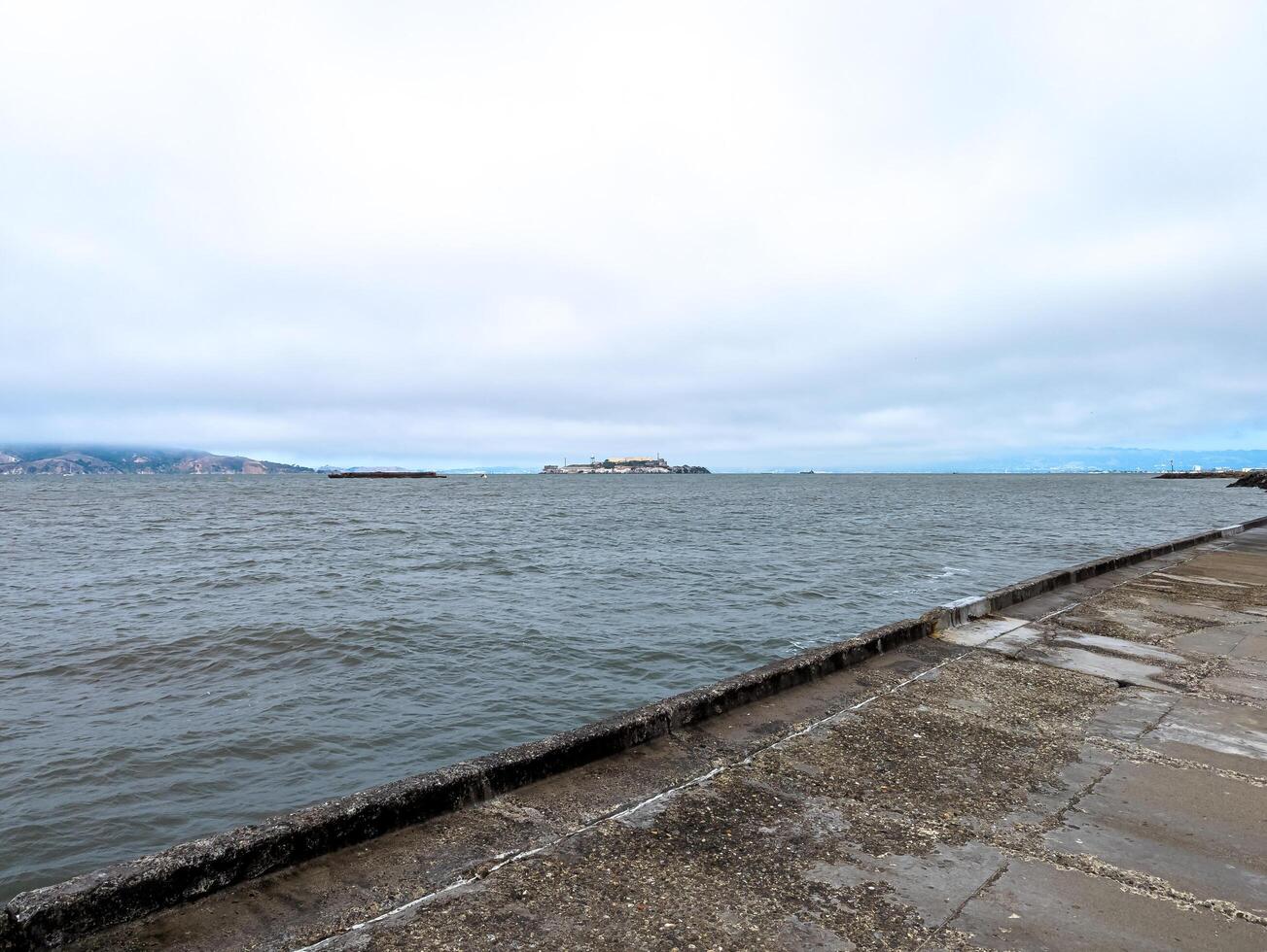 View of Alcatraz Island in San Francisco Bay, USA. Alcatraz prison on top of a rocky outcrop in cloudy weather photo