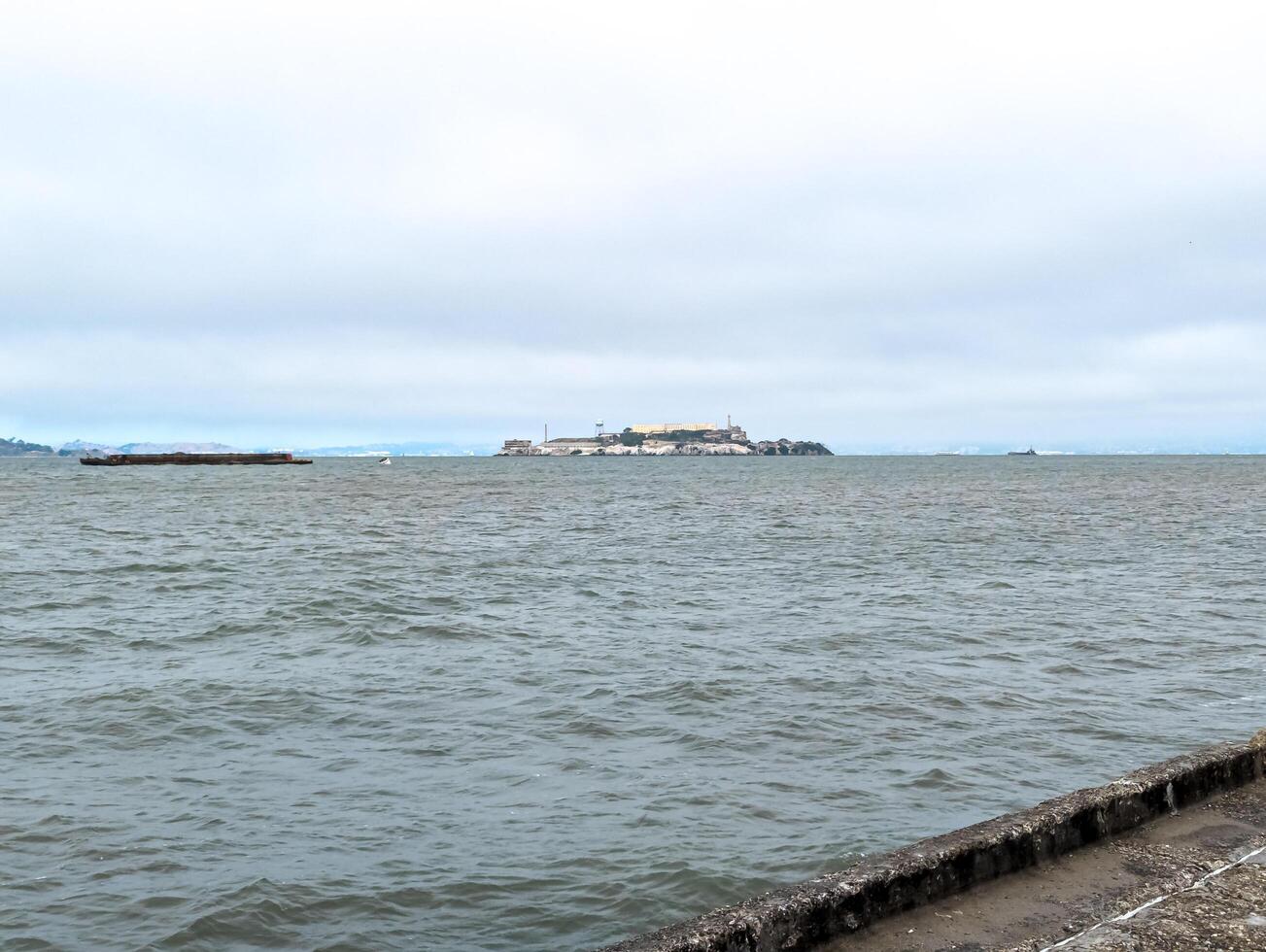View of Alcatraz Island in San Francisco Bay, USA. Alcatraz prison on top of a rocky outcrop in cloudy weather photo