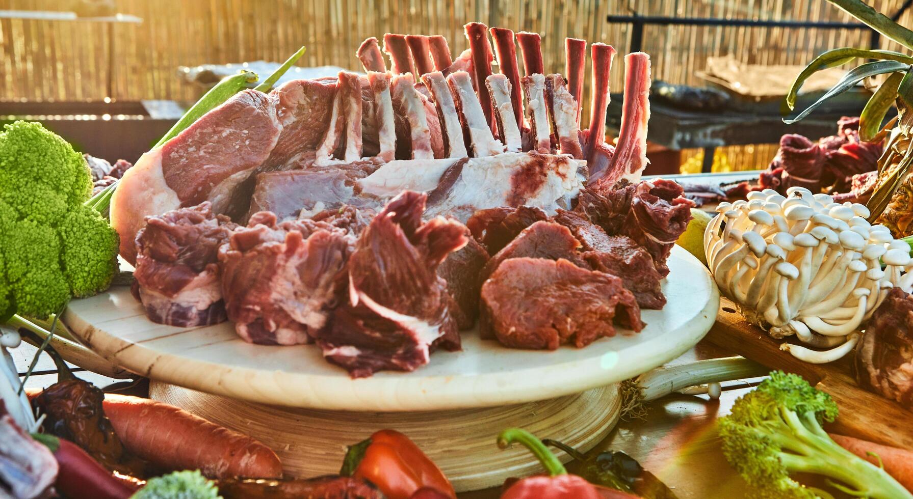 A variety of raw meat cuts, including ribs and tenderloin, displayed on a wooden board, ready for preparation and cooking photo