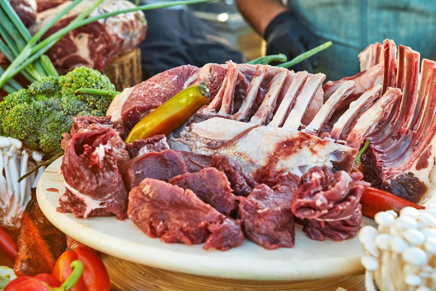 A variety of raw meat cuts, including ribs and tenderloin, displayed on a wooden board, ready for preparation and cooking photo
