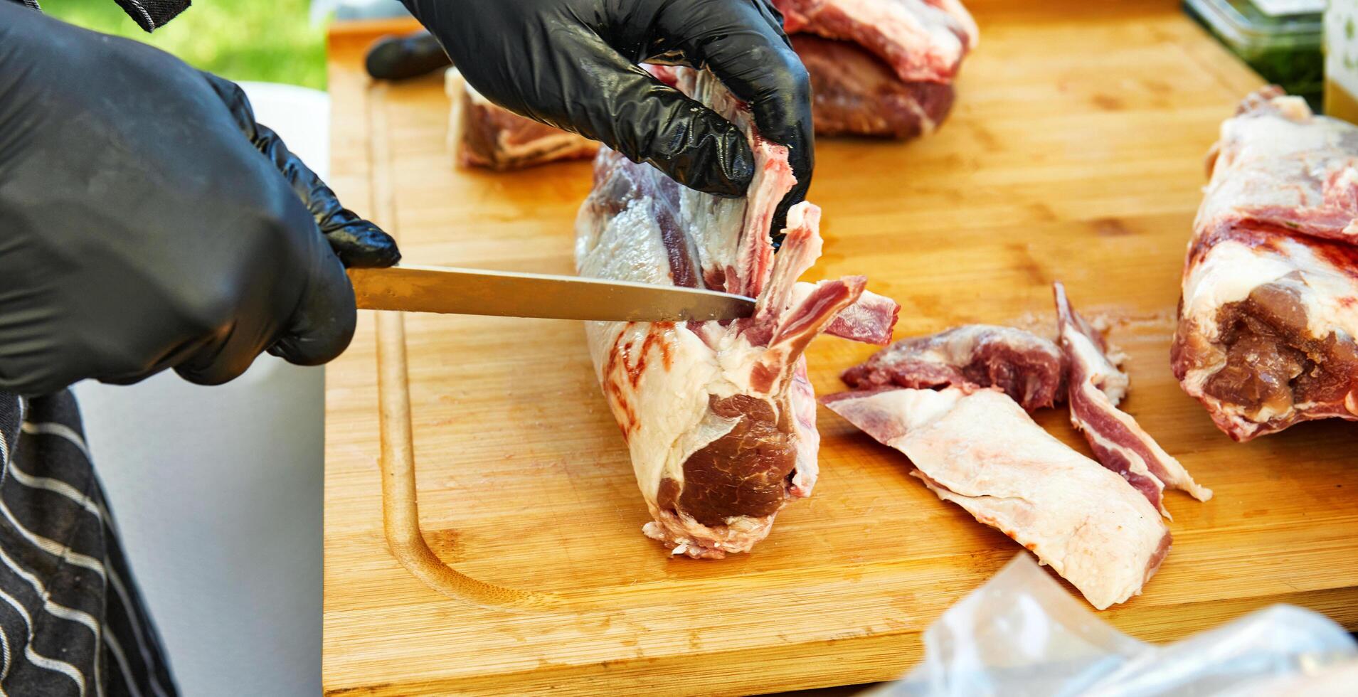 Chef slicing lamb for barbecue at event photo