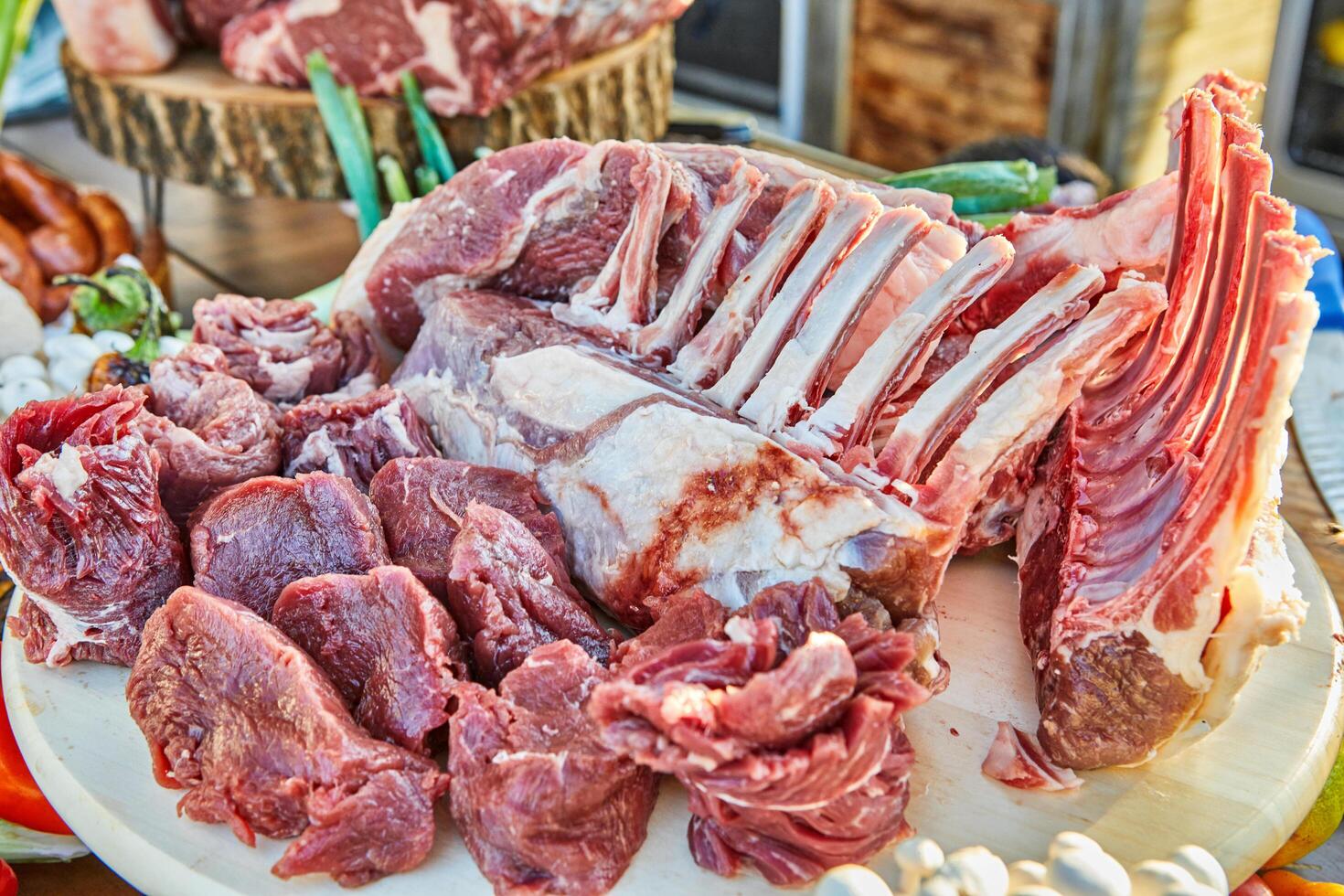 A variety of raw meat cuts, including ribs and tenderloin, displayed on a wooden board, ready for preparation and cooking photo